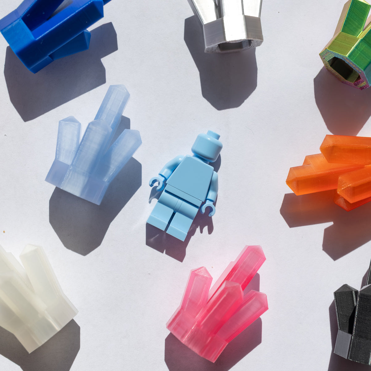 3D-printed crystal clusters surrounding a light blue minifigure for scale