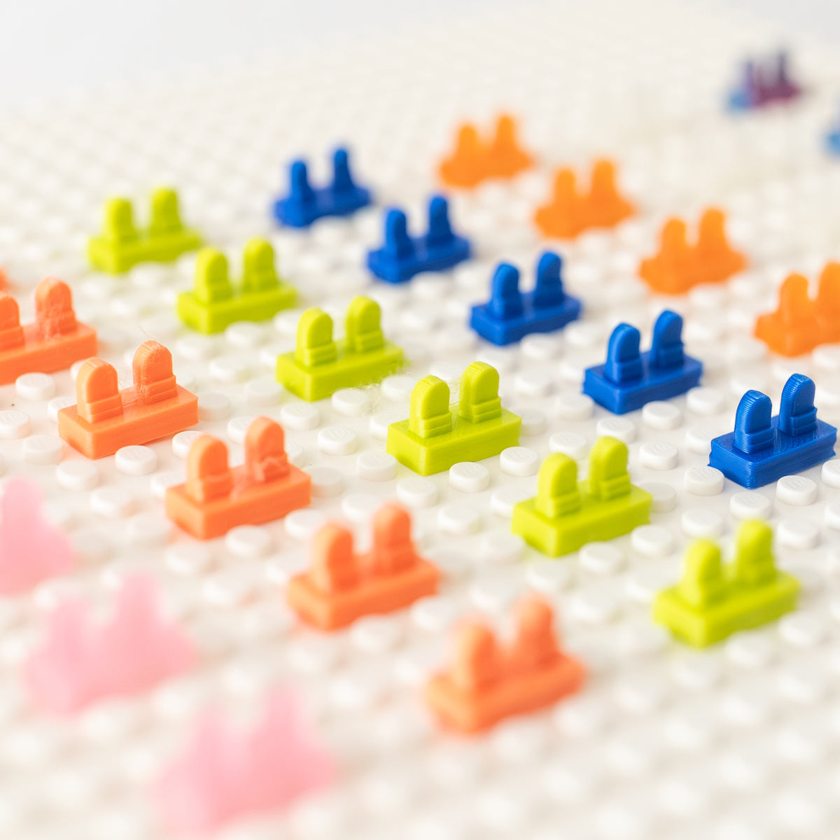 Colorful 3D-printed minifigure heel savers arranged on a white baseplate