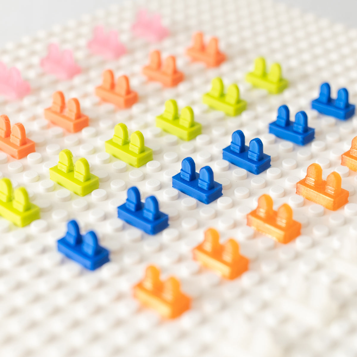 Colorful 3D-printed heel savers arranged diagonally on a white baseplate