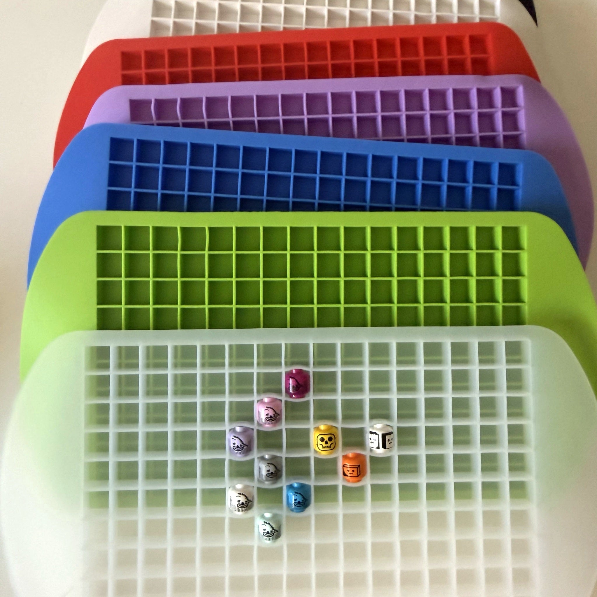 Black, white, red, purple, blue, and lime green silicone head holder trays